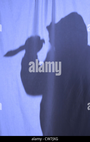 man with weapon behind a curtain Stock Photo