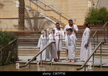 A family waits to be baptized on the banks of River Jordan Stock Photo