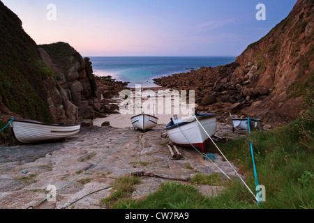 Sunrise at Porthgwarra Cornwall with fishing boast tied up on the cobbled slipway Stock Photo