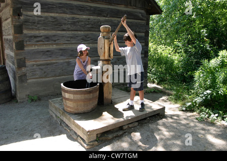 Two small Children are playing on a outdoor water pump 19th Century;Black Creek Pioneer Village,  Toronto,Ontario;Canada Stock Photo