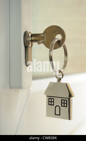 HOUSE KEY IN DOOR LOCK WITH HOUSE KEY FOB RE HOME BUYERS FIRST TIME BUYING HOMES HOUSES HOUSING MARKET MORTGAGES INCOMES UK Stock Photo