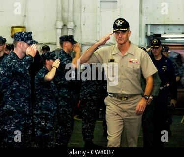 Capt. David Lausman, commanding officer of the aircraft carrier USS George Washington (CVN 73), salutes sailors in the ship's hangar bay during an all-hands call. George Washington is currently pier side in Yokosuka, Japan, and making preparations to return to sea. Stock Photo