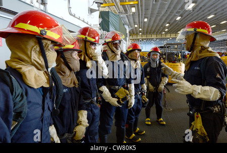 A five-man-hose team prepares for a firefighting simulation during a General Quarters drill aboard the forward-deployed amphibious assault ship USS Bonhomme Richard (LHD 6). Bonhomme Richard, commanded by Capt. Daniel Dusek, is the lead of the forward-deployed amphibious ready group.