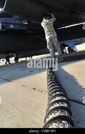 A crew chief from the 5th Aircraft Maintenance Squadron plugs an air cart into a B-52H Stratofortress prior to a mission at Minot Air Force Base, N.D., Aug. 10, 2012. As part of Air Force Global Strike Command, crew chiefs work endlessly to preserve our nationâ€™s security by providing combat-ready forces for nuclear deterrence and global strike operations. Stock Photo