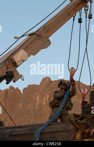 Spc. Jonathan Baird, who serves as a stryker maintainer with the Logistical Support Team, 2nd Battalion, 1st Infantry Regiment, 2nd Stryker Brigade Combat Team, 2nd Infantry Division, secures straps to a CH-47 helicopter during a recovery mission in Arghandab, Afghanistan Aug. 13. The LST was given the challenging task of retrieving a downed aircraft using the stryker recovery system. Stock Photo