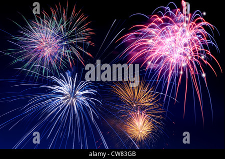 Fireworks of several colors bursting against a dark blue sky Stock Photo