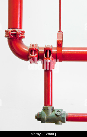 Red water pipes against a white wall Stock Photo