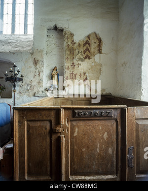 DISSERTH 13TH CENTURY CHURCH, RADNORSHIRE WALES. THE WOODEN BOX PEW IS DATED 1687. Statue of the Virgin Mary in niche in wall. Stock Photo