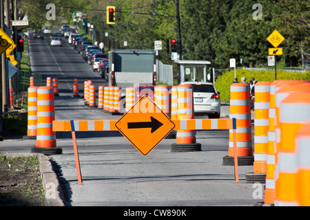 Working area warning in middle of the road, in a sunny day...a barrier wit an orange square with a black horizontal arrow Stock Photo