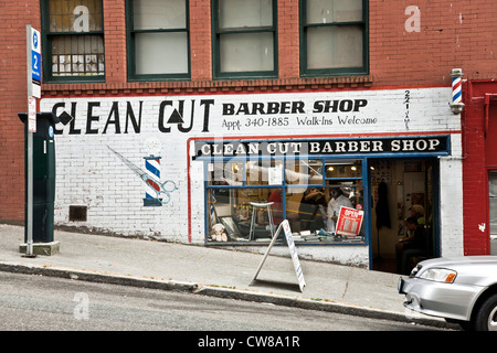 old fashioned neighborhood barber shop with traditional pole & handsome signage graphics in Pioneer Square District Seattle Stock Photo