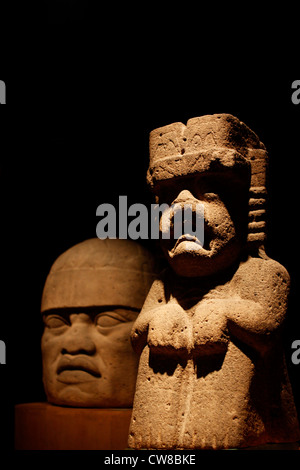 A sculpture is displayed in front of the Olmec giant head in the National Museum of Anthropology in Mexico City Stock Photo