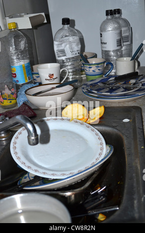 dirty sink full of dishes, bowls, cups and orange peels. Stock Photo