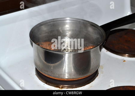 eggs boiling in saucepan on the stove Stock Photo
