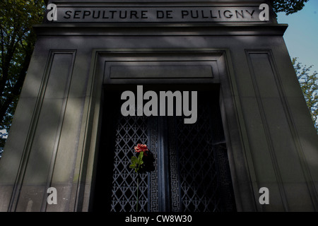 Single red rose attached to the gates of the mausoleum for the Pulligny family in the Pere Lachaise cemetery, Paris. Stock Photo