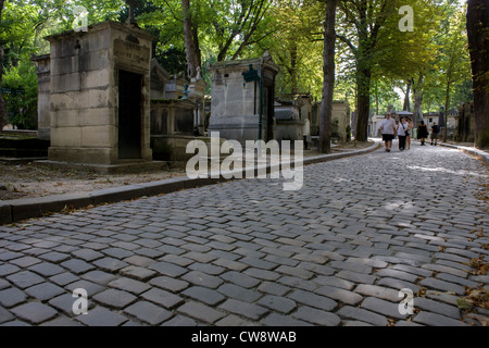 Wide cobbled avenue in the Pere Lachaise cemetery, Paris. Père Lachaise Cemetery (Cimetière du Père-Lachaise) is the largest cemetery in the city of Paris, France (44 hectares (110 acres) though there are larger cemeteries in the city's suburbs. Père Lachaise is in the 20th arrondissement, and is reputed to be the world's most visited cemetery, attracting hundreds of thousands of visitors annually to the graves of those who have enhanced French life over the past 200 years. It is also the site of three World War I memorials. Stock Photo