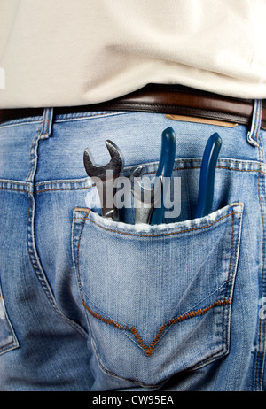 Various hand tools in mans jeans back pocket. Stock Photo