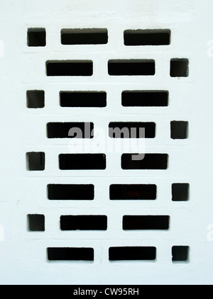 Geometric white textured and patterned wall with rectangular holes for background. Stock Photo
