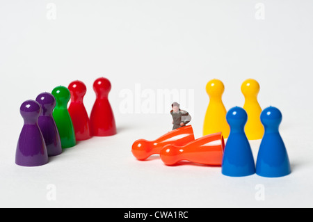 Colourful pawns and a toy figure Stock Photo