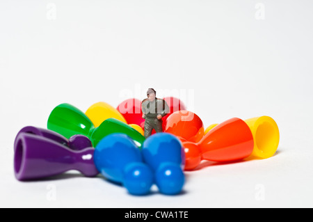 Colourful pawns and a toy figure Stock Photo