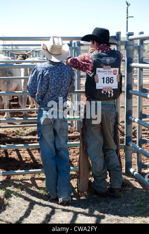 Two young contestants of the Mount Isa Rodeo watching the bulls in the stockyard Stock Photo