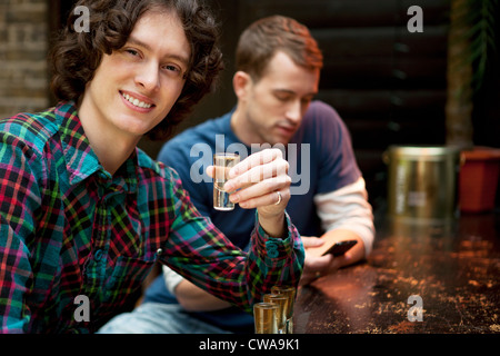 Two men at bar, one holding shot glass Stock Photo