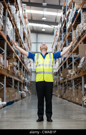 Man with arms raised in warehouse, portrait Stock Photo