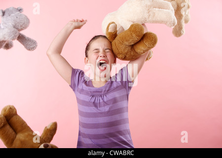 Girl throwing teddy bears Stock Photo