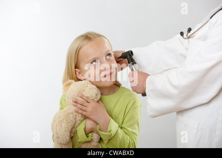 Doctor examining girl's ear Stock Photo