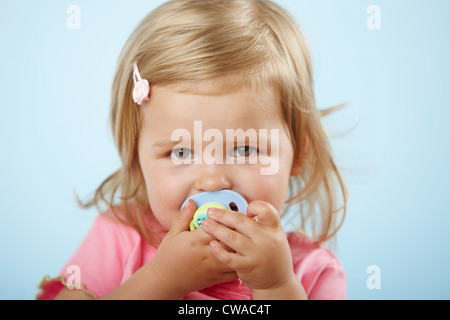 Girl with pacifier in mouth Stock Photo