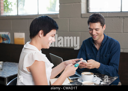 Businesspeople using smartphones in cafe Stock Photo