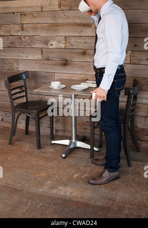 Businessman finishing drink in cafe Stock Photo