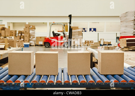 Four cardboard boxes on conveyor belt Stock Photo