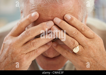 Senior man with head in hands, close up portrait Stock Photo