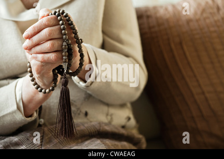 Senior woman holding rosary beads Stock Photo