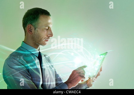 Businessman using digital tablet with lights Stock Photo