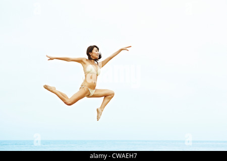 https://l450v.alamy.com/450v/cwaeh7/young-woman-in-bikini-jumping-on-beach-cwaeh7.jpg