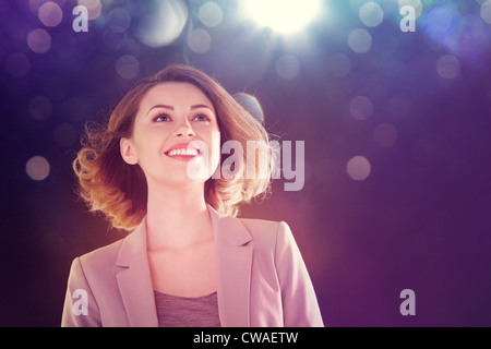 Young woman looking up at lights Stock Photo