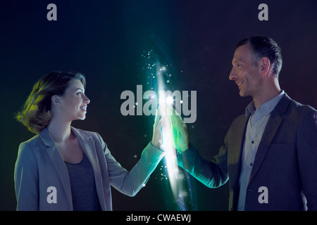 Businesspeople connecting through light Stock Photo