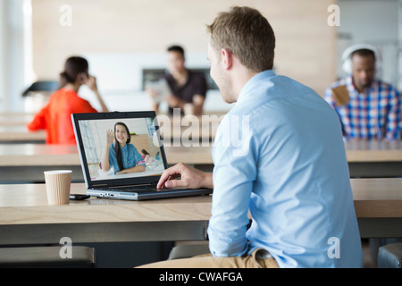 Young man using laptop to have video call with girlfriend Stock Photo