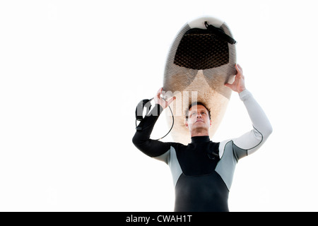 Surfer carrying surfboard on head Stock Photo