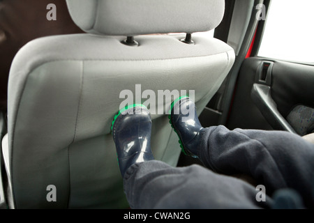 Childs feet on back of car seat Stock Photo