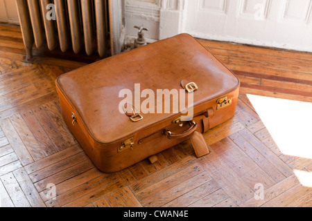 Brown leather suitcase on wooden floor Stock Photo