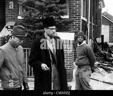 Malcolm X (center, 1925-1965), talks to a reporter after a fire bomb was thrown in his house. February 14, 1965. CSU Archives Stock Photo
