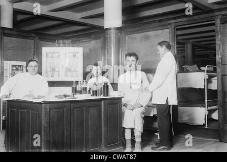 Two recently bathed men are given vaccinations by the doctor at New York City's Municipal Lodging House. Ca. 1910. Stock Photo