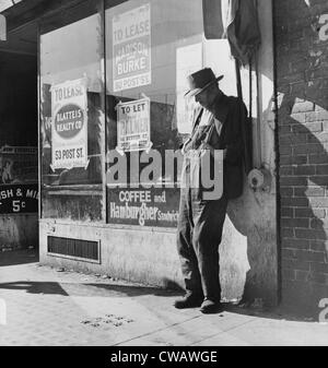 Lone man in farmer's overalls, on San Francisco's Skid Row at Howard Street. Ruined farmers from the Midwest added to the Stock Photo