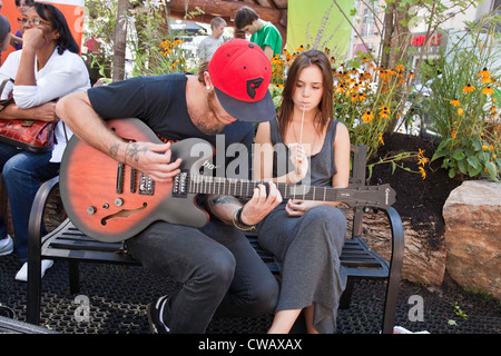 Young Man playing guitar for his Girl Friend on Celebrate Yonge; the longest street in the World; Toronto;Ontario;Canada; Stock Photo