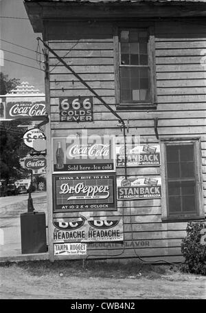 Side of a store, showing advertising signs, including 666 cold medicine ...