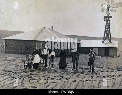 A farm family standing in front of sod house and windmill. Coburg, Nebraska 1885 Stock Photo