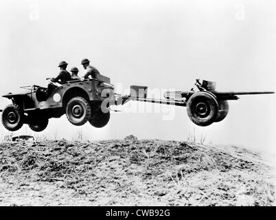 The new 'jeep' in mid-air as it pulls a small artillery piece ca. 1941 Stock Photo