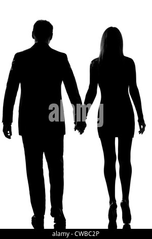 Back silhouette of couple walking holding hands on the street in rain ...